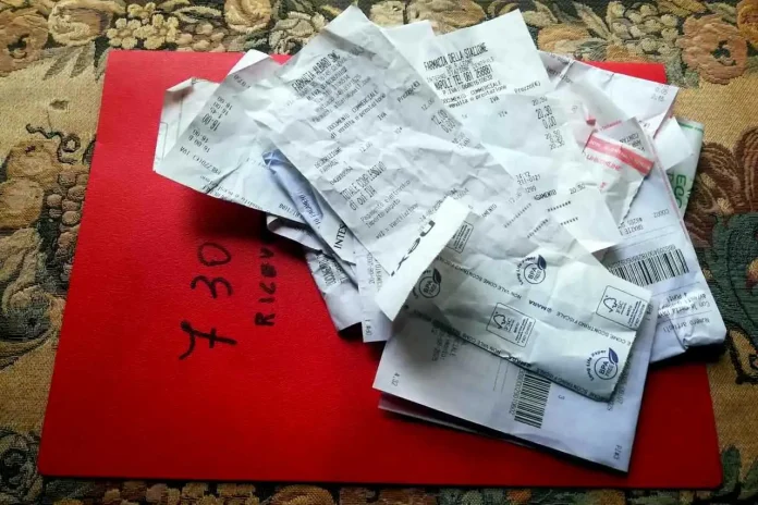 Mucchietto di scontrini farmaceutici conservati per il 730 Scontrini farmaceutici ammucchiati su cartellina delle ricevute cartacee per il 730