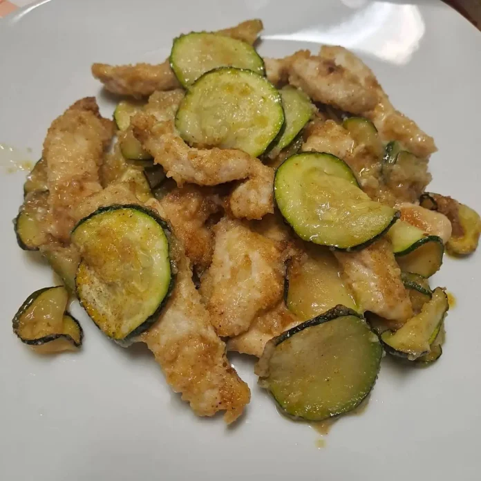 Porzione di straccetti di petto di pollo con zucchine al forno su piatto individuale Straccetti di pollo con zucchine al forno su piatto bianco