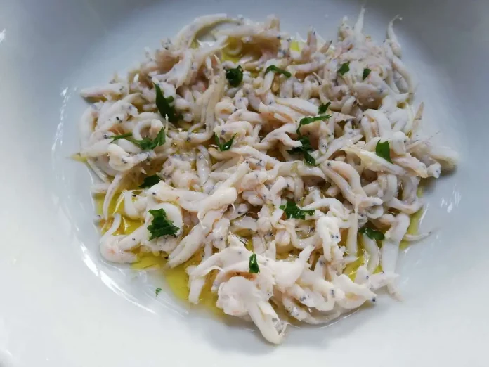 Rossetti bolliti con olio,limone e prezzemolo su piatto bianco