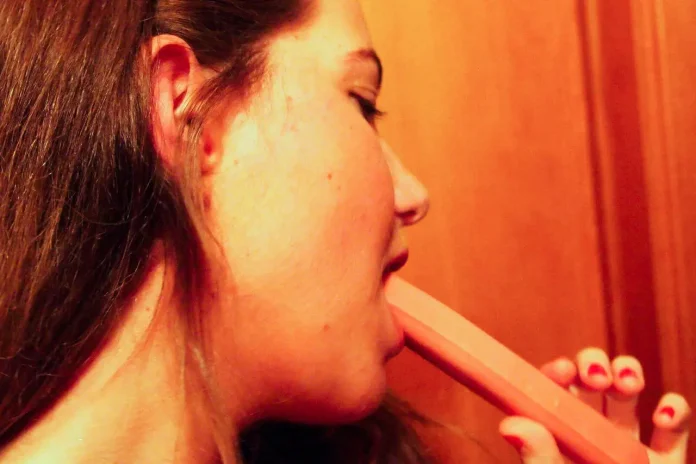 Ragazza che mangia un wurstel crudo