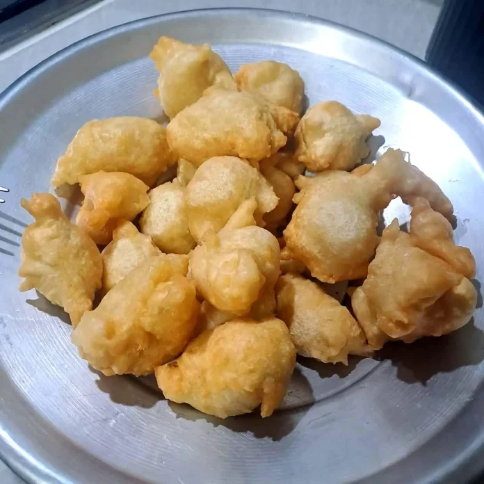 Vassoio metallico con sopra zeppole di pasta cresciuta salate Zeppole di pasta cresciuta salate su vassoio di metallo