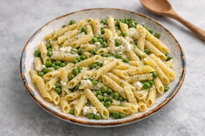 Piatto rustico contenente appetitose penne con piselli e ricotta Penne con piselli e ricotta servite in piatto rustico