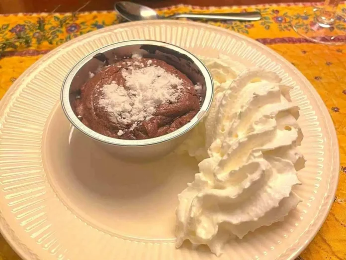 Pirottino contenente coviglia al cioccolato con accanto panna montata Coviglia al cioccolato napoletana servita in pirottino di alluminio con panna montata a parte